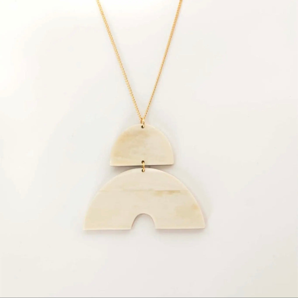 Héritage Arc Necklace — two-piece geometric pendant on a gold-tone chain 